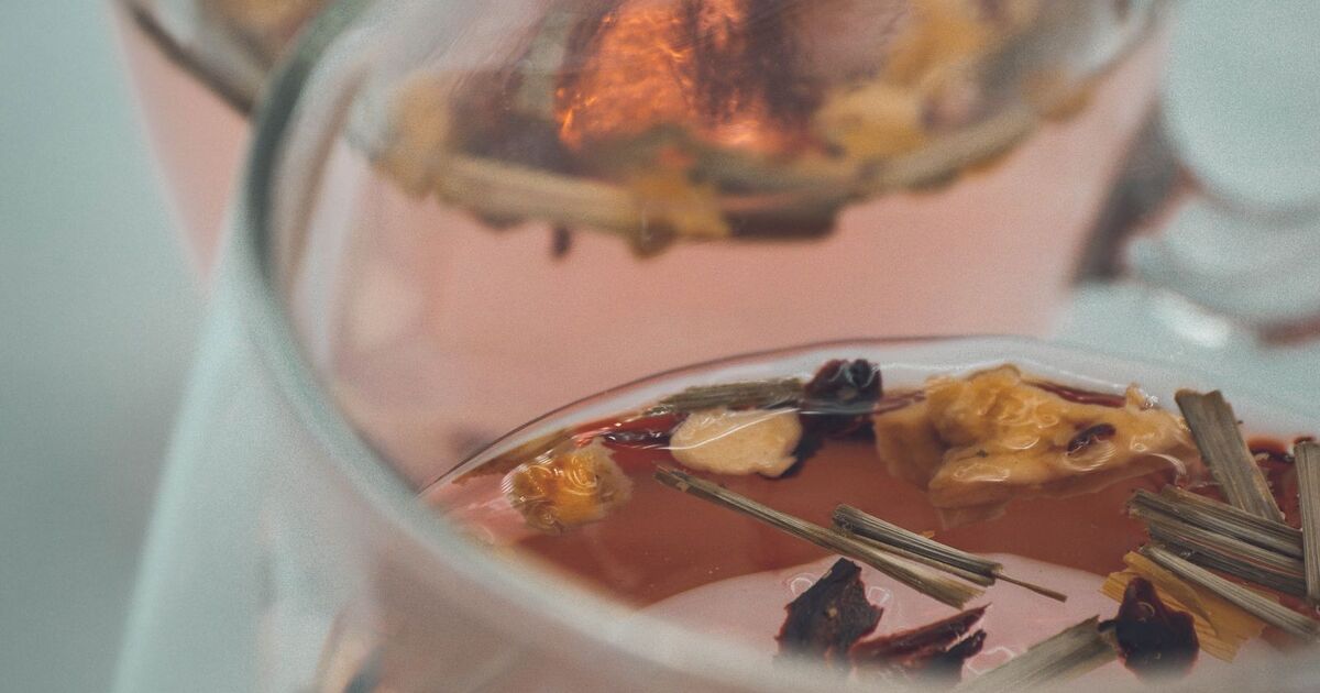 Tasses en cristal remplies d'infusion claire, ambiance lumineuse de table dressée